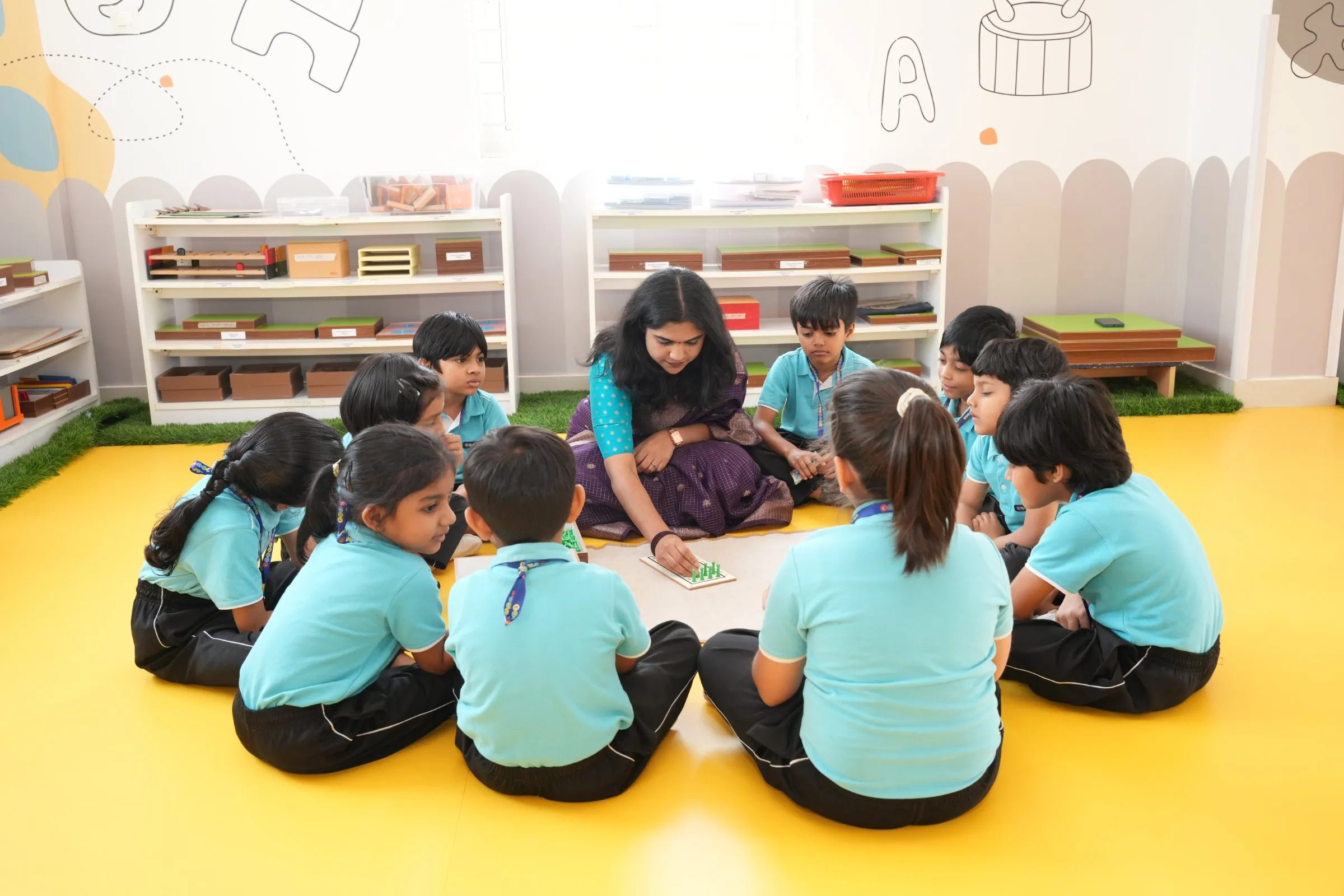 Children at Crossmaze sitting together with their teacher, engaging in joyful, interactive group learning.